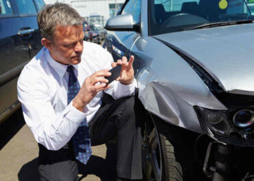 Insurance Adjuster Inspecting a Damaged Car